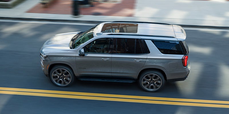 A 2025 Chevrolet Tahoe driving on a paved street